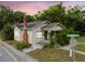 Charming home featuring a brick chimney, a small porch, and mature trees surrounding the property at 702 W Virginia Ave, Tampa, FL 33603