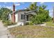 Charming home with a brick chimney, covered porch, and mature landscaping at 702 W Virginia Ave, Tampa, FL 33603