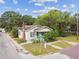 Aerial view of a home on a corner lot, featuring brick accents and mature trees at 702 W Virginia Ave, Tampa, FL 33603
