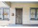 Close up exterior view of the front door and front windows with bars on them at 702 W Virginia Ave, Tampa, FL 33603