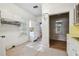 A bright kitchen, white cabinets, and a view into a room with wood paneling and vintage wallpaper at 702 W Virginia Ave, Tampa, FL 33603