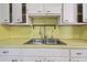 A close-up on the kitchen sink shows the faucet and cabinet hardware at 702 W Virginia Ave, Tampa, FL 33603