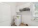 Laundry area with a modern washing machine and overhead storage at 702 W Virginia Ave, Tampa, FL 33603