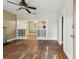 Open living room with hardwood floors, a ceiling fan, and a view into another room through an open columned wall at 702 W Virginia Ave, Tampa, FL 33603
