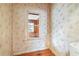 Room featuring vintage wallpaper and a wood floor, viewed through window at 702 W Virginia Ave, Tampa, FL 33603