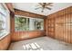 Wood paneled room with ceiling fan, windows letting in sunlight, and a wood door at 702 W Virginia Ave, Tampa, FL 33603