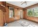 Bright sunroom with wood paneled walls, built in shelves, and views of the lush backyard at 702 W Virginia Ave, Tampa, FL 33603