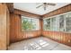 Well-lit sunroom featuring wood paneled walls and large windows overlooking the green outdoors at 702 W Virginia Ave, Tampa, FL 33603
