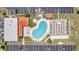 Aerial view of community pool, shuffleboard, parking, and outdoor seating area at 7053 El Conquistador St, Zephyrhills, FL 33541