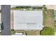 Aerial view of home with a metal roof, landscaping, and close proximity to neighbors at 7053 El Conquistador St, Zephyrhills, FL 33541