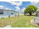 Well-maintained backyard with lush green grass, a cozy fire pit, and mature landscaping at 7053 El Conquistador St, Zephyrhills, FL 33541