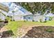 Landscaped backyard with healthy grass, an outdoor firepit and a neighboring mobile home at 7053 El Conquistador St, Zephyrhills, FL 33541