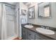 Bathroom featuring dual sinks, framed mirrors, and a walk-in shower at 7053 El Conquistador St, Zephyrhills, FL 33541