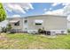 Side exterior of a home, featuring a ladder, air conditioning unit, and tidy landscaping at 7053 El Conquistador St, Zephyrhills, FL 33541
