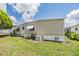 Side view of a single-story home with well-maintained landscaping and a visible air conditioning unit at 7053 El Conquistador St, Zephyrhills, FL 33541
