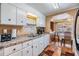 Kitchen featuring white cabinets, laminate countertops, stainless steel appliances, and cozy breakfast nook at 7053 El Conquistador St, Zephyrhills, FL 33541