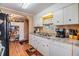 Traditional kitchen with white cabinets, granite countertops, stainless steel appliances, and wood-look flooring at 7053 El Conquistador St, Zephyrhills, FL 33541