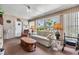 Cozy living room with a ceiling fan, a comfortable sofa, and a large window offering natural light at 7053 El Conquistador St, Zephyrhills, FL 33541