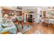 Bright and airy living room showcasing hardwood floors, comfortable seating, and seamless flow to dining area at 7053 El Conquistador St, Zephyrhills, FL 33541
