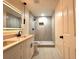Modern bathroom featuring a dual sink vanity, illuminated mirror, and sleek, glass-enclosed shower with updated fixtures at 733 Holly Ter, Brandon, FL 33511