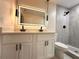 Modern bathroom featuring a dual sink vanity, illuminated mirror, and sleek, glass-enclosed shower with updated fixtures at 733 Holly Ter, Brandon, FL 33511