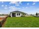 The home's backyard features a spacious grassy area and partial views of the home at 755 Maldives Trl, Sarasota, FL 34234