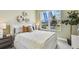 Bright bedroom boasts a plush bed, stylish decor, and a large window with natural light at 755 Maldives Trl, Sarasota, FL 34234