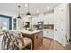 A kitchen area featuring a center island with seating, white cabinets, and stainless steel appliances at 755 Maldives Trl, Sarasota, FL 34234