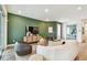 Well-lit living room boasts a vibrant green accent wall, contemporary furniture, and recessed lighting at 755 Maldives Trl, Sarasota, FL 34234