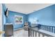 Bright blue bedroom with a crib, changing table, and a comfortable recliner at 812 Regent Circle S, Brandon, FL 33511