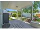 Covered back porch offers a view of the yard with a stone path, lush plants, and detached garage at 834 26Th N Ave, St Petersburg, FL 33704