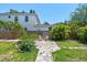Spacious backyard boasts a stone pathway, lush grass, garden area, and a privacy fence at 834 26Th N Ave, St Petersburg, FL 33704