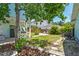 Relaxing backyard featuring a mature shade tree, lush grass, garden, stone path, and bike at 834 26Th N Ave, St Petersburg, FL 33704