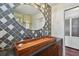 Stylish bathroom features a wooden vessel sink, oval mirror, and unique patterned tile wall at 834 26Th N Ave, St Petersburg, FL 33704