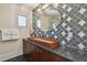 Modern bathroom vanity with black and white backsplash, wood accents, and an oval mirror at 834 26Th N Ave, St Petersburg, FL 33704