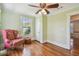 Cozy bedroom with beautiful hardwood floors, statement chair, ceiling fan, and natural light at 834 26Th N Ave, St Petersburg, FL 33704