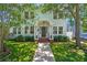 Charming home exterior featuring a covered porch with pillars, lush greenery, and a well-manicured lawn at 834 26Th N Ave, St Petersburg, FL 33704