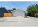 A detached garage with a white door sits at the end of a concrete driveway next to a wooden fence at 834 26Th N Ave, St Petersburg, FL 33704
