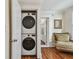 Upstairs laundry closet with stacked washer and dryer, white trim, and hardwood floors at 834 26Th N Ave, St Petersburg, FL 33704