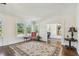 Bright living room with a large rug, three windows, and a glimpse into an office space at 834 26Th N Ave, St Petersburg, FL 33704