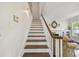 View of staircase with white walls and trim, stained wood steps and railing, and decorative mirror at 834 26Th N Ave, St Petersburg, FL 33704