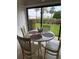 Cozy dining area with seating for four, overlooking a well-manicured lawn and mature palm trees at 845 S Gulfview Blvd # 110, Clearwater Beach, FL 33767