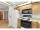 Kitchen with white appliances, wood cabinets, and a tile backsplash at 10512 Red Coach St, Spring Hill, FL 34608