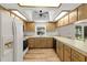 Cozy kitchen featuring wood cabinets, fan and lighting and a window for natural light at 10512 Red Coach St, Spring Hill, FL 34608
