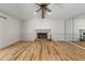 Expansive living area with hardwood floors, a classic fireplace, and a mirrored wall adding depth to the space at 10512 Red Coach St, Spring Hill, FL 34608