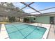 A bright blue in-ground pool with a screened enclosure for sunbathing and fun at 10512 Red Coach St, Spring Hill, FL 34608