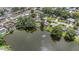 Scenic aerial view of a tranquil lake surrounded by homes, lush greenery, and mature trees at 1179 Lazy Lake W Rd, Dunedin, FL 34698