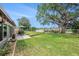 Backyard showcasing a lush lawn, patio with outdoor seating, and a view of the lake at 1179 Lazy Lake W Rd, Dunedin, FL 34698