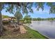 Peaceful backyard oasis with a spacious deck overlooking a serene lake with fountain features at 1179 Lazy Lake W Rd, Dunedin, FL 34698