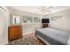 Inviting bedroom featuring hardwood floors, ceiling fan, and large sunny windows at 1179 Lazy Lake W Rd, Dunedin, FL 34698